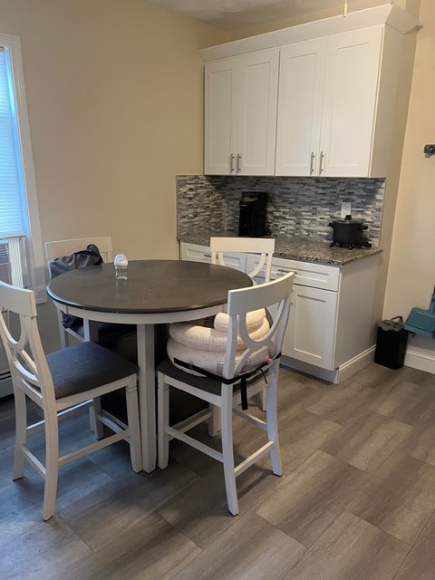 Dining table and chairs beside white cabinets at Acapulco