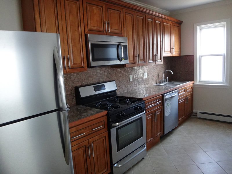 Renovated kitchen with wood cabinets and stainless appliances at Acapulco