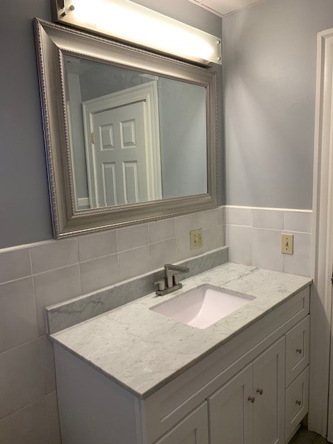 Bathroom vanity with marble top and framed mirror at Aruba