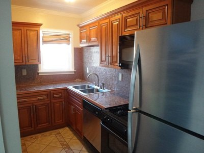 Kitchen with wood cabinets, stainless refrigerator and dishwasher at Cabo