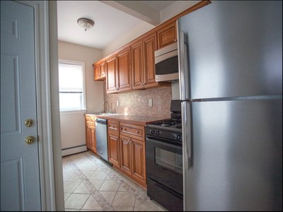 Galley kitchen with wood cabinets and stainless refrigerator at Cancun