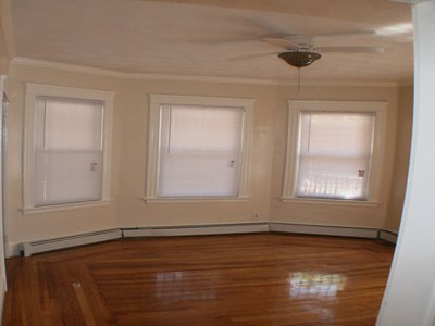 Living room with bay windows, hardwood floor and ceiling fan at Cancun