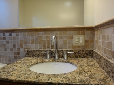 Bathroom vanity with granite counter and tile backsplash at Costa Rica