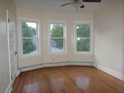 Bedroom with bay windows, hardwood floor and ceiling fan at Costa Rica