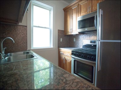 Kitchen with granite counter, stainless range and microwave at Daytona Beach
