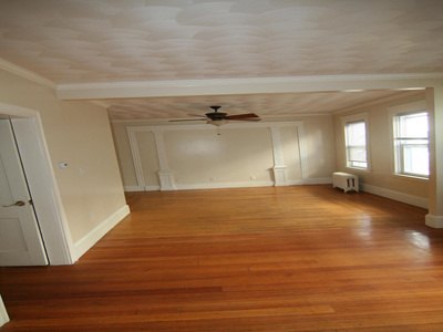Large living room with hardwood floors and ceiling fan at Daytona Beach