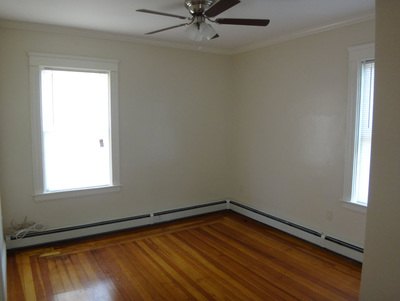Bedroom with two windows, hardwood floor and ceiling fan at Jamaica