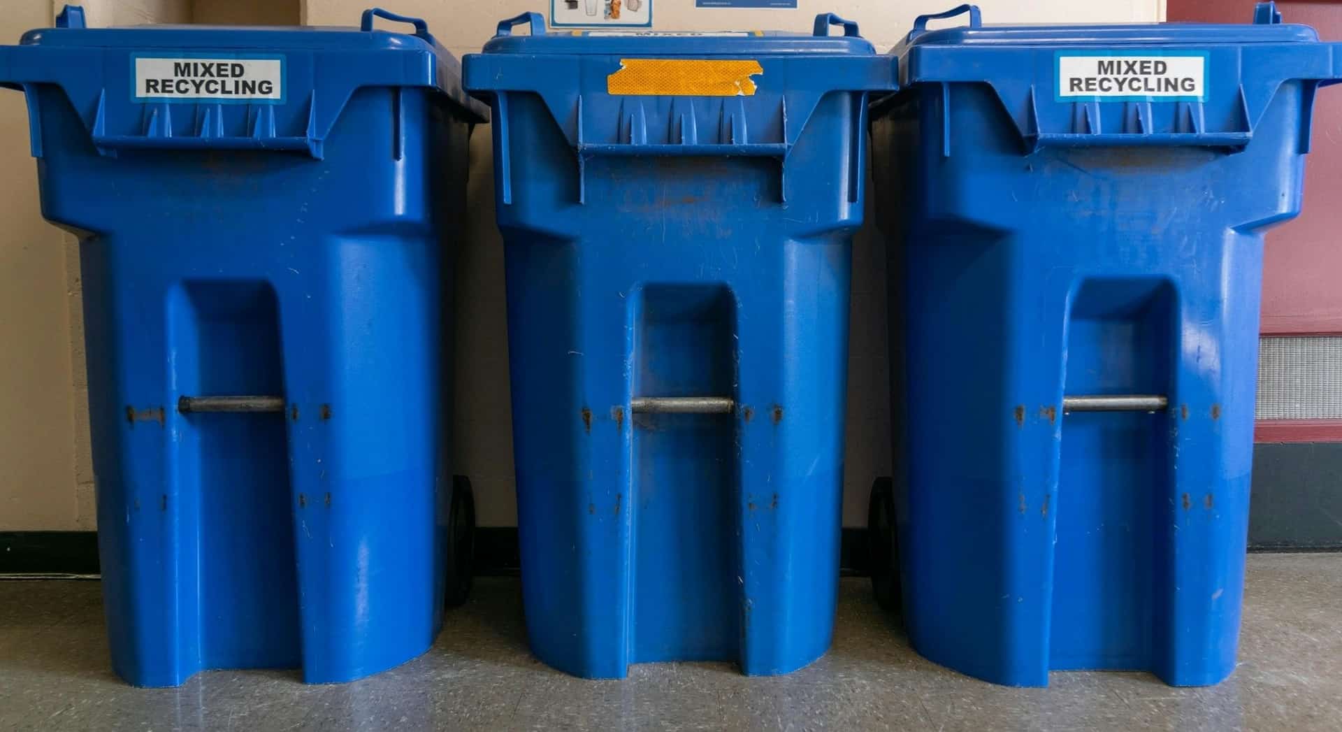 Blue mixed-recycling carts lined up ready for collection