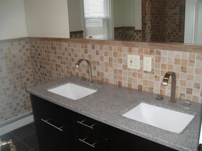 Double-sink bathroom vanity with granite top and tile backsplash at South Beach